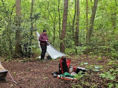 A one man tent and bivy pitched in some deciduous woods.