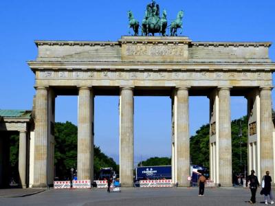Brandenburg Gate in bright morning light with only a few people visible.