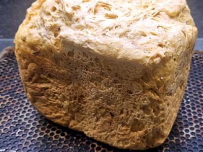 Square tomato and cheese loaf from a bread machine, with a rough, bubbled top crust.